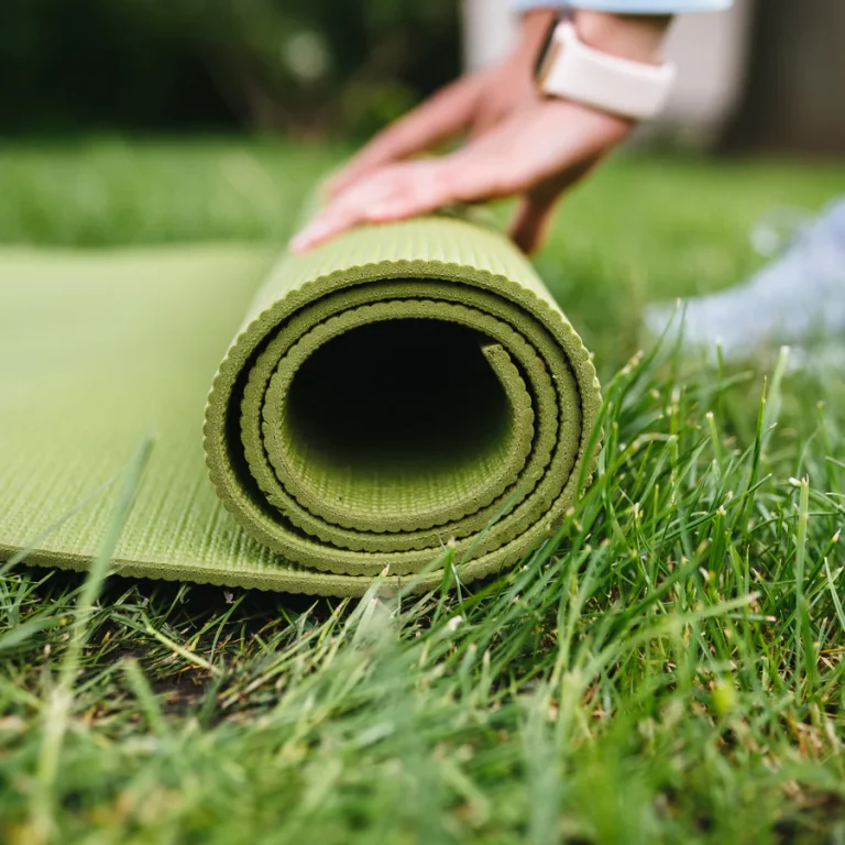 Esterilla de yoga enrollada sobre el césped